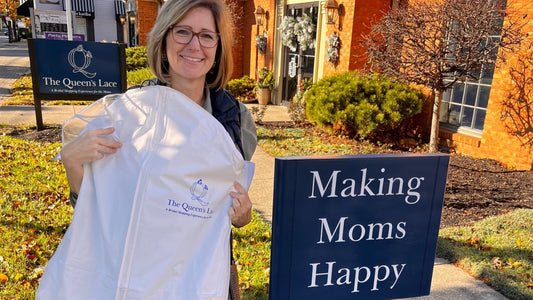 mother of the groom standing next to a sign that says Making Moms Happy